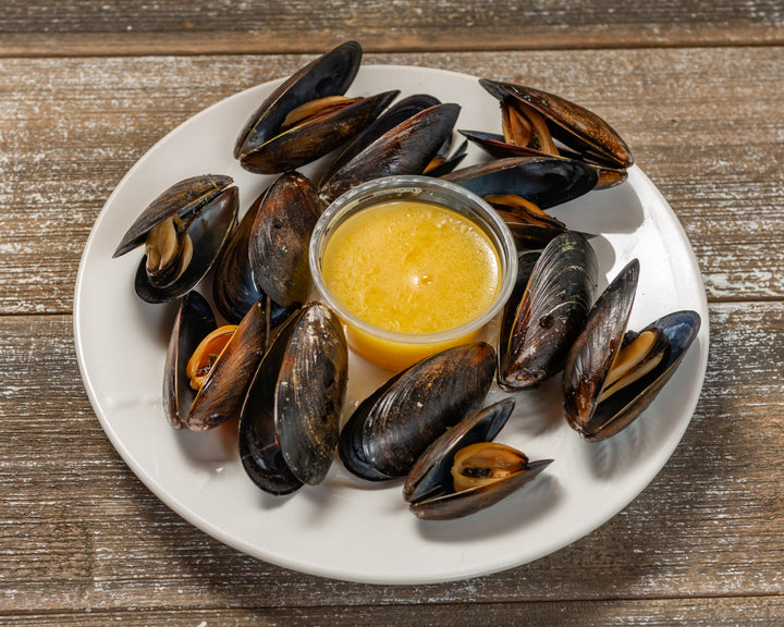 Steamed mussels prepared on a plate with butter.