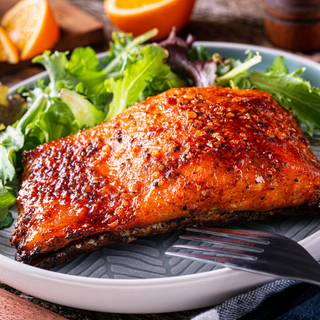 Wild-Caught Sockeye Salmon prepared on a plate with lettuce.