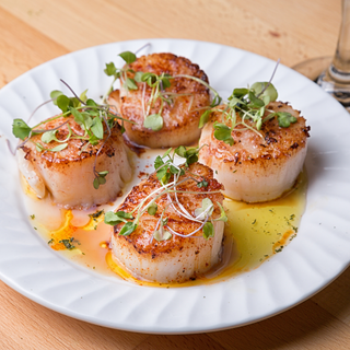 Pan Seared Scallops prepared on a plate in butter sauce.